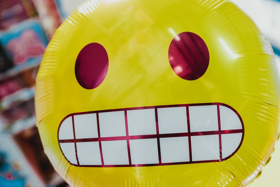 yellow inflatable smiling emoji balloon in focus photography